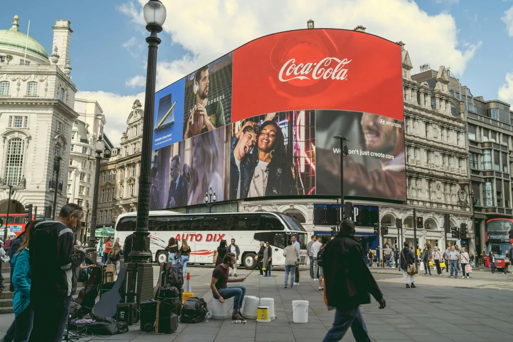 pexels-photo-1433050-1433050 Tourists and buskers at Piccadilly Circus under iconic billboards in London, a center of urban life and commerce.