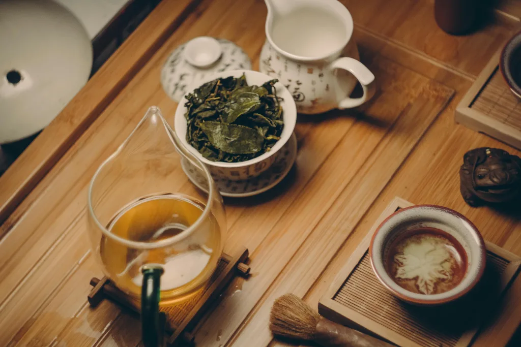 tea Warm, inviting tea ceremony scene with traditional teapot, leaves, and cup on a wooden table.