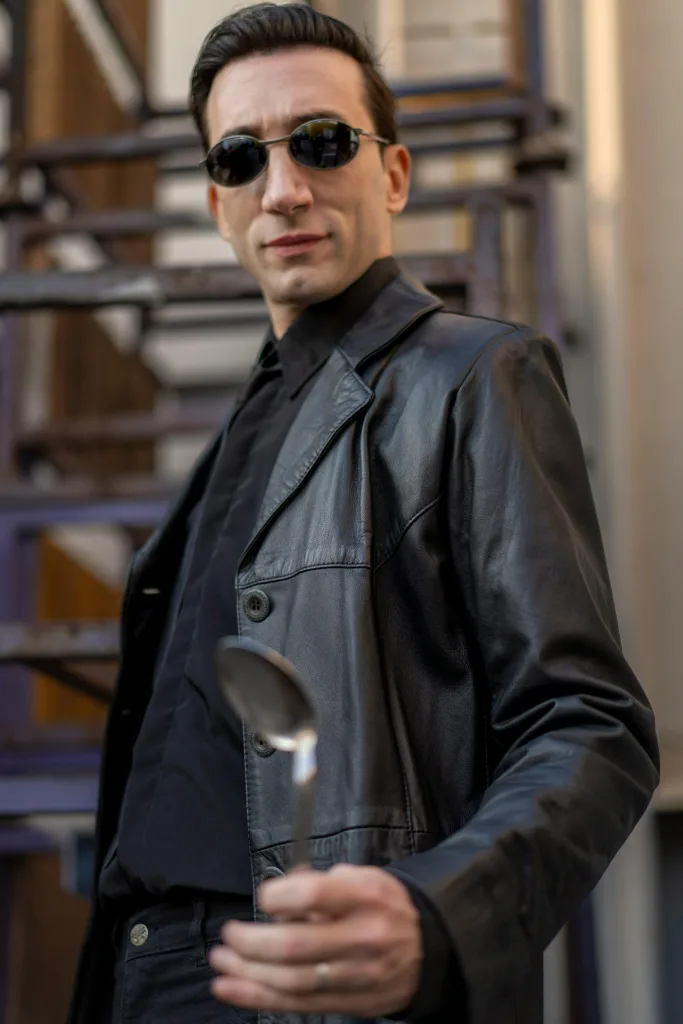 Sci-fi Man in Neo cosplay from The Matrix sci-fi movies with black leather jacket and sunglasses.