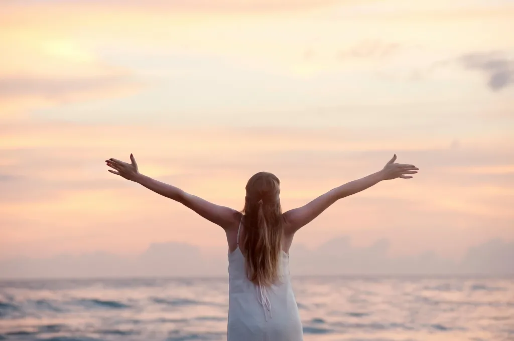 motivational A woman enjoying a serene sunset on Unawatuna Beach, Sri Lanka, depicting peace and freedom. she is motivated by quotes