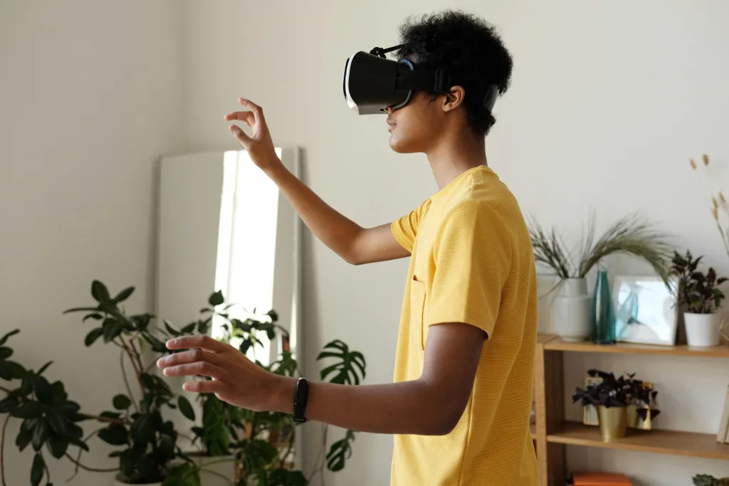 pexels-photo-4144147-4144147 Teen enjoying virtual reality with VR headset at home, surrounded by plants.