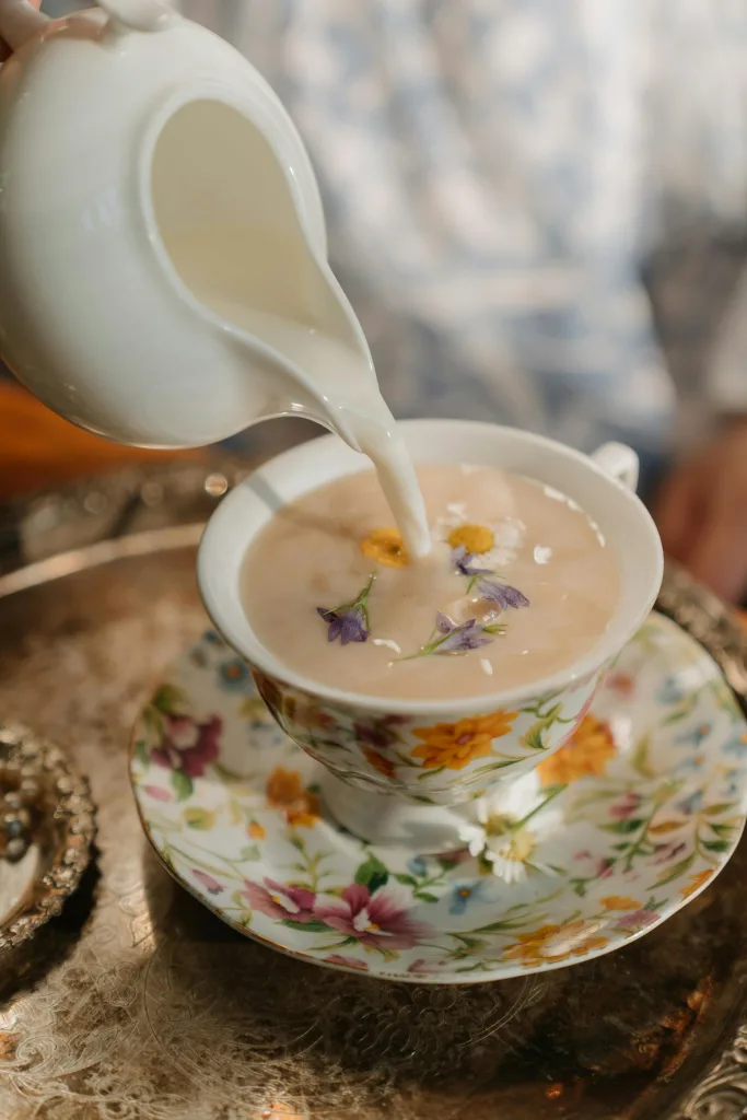 pexels-photo-4974543-4974543 Pouring milk into a beautifully decorated floral porcelain teacup.