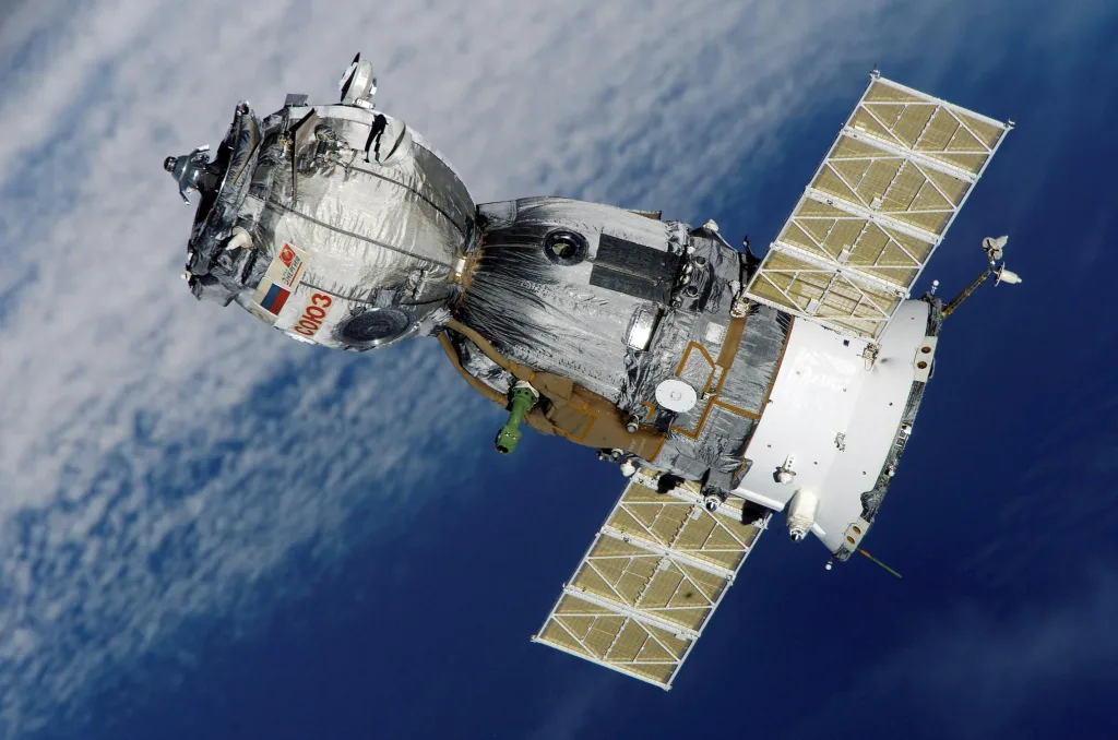 satellite-soyuz-spaceship-space-station-41006-41006 Close-up of Soyuz spacecraft orbiting Earth with solar panels extended, showcasing space exploration technology. it is also space hotels