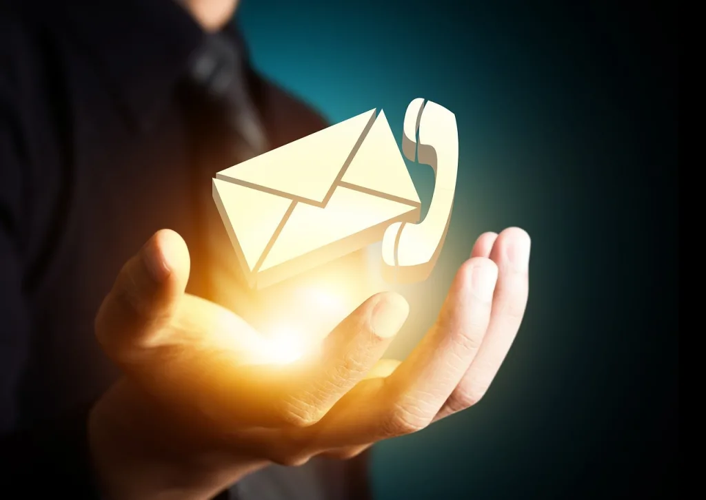 A person showing hand where mail and phone icon is seen in his hand simbolizing contact us .